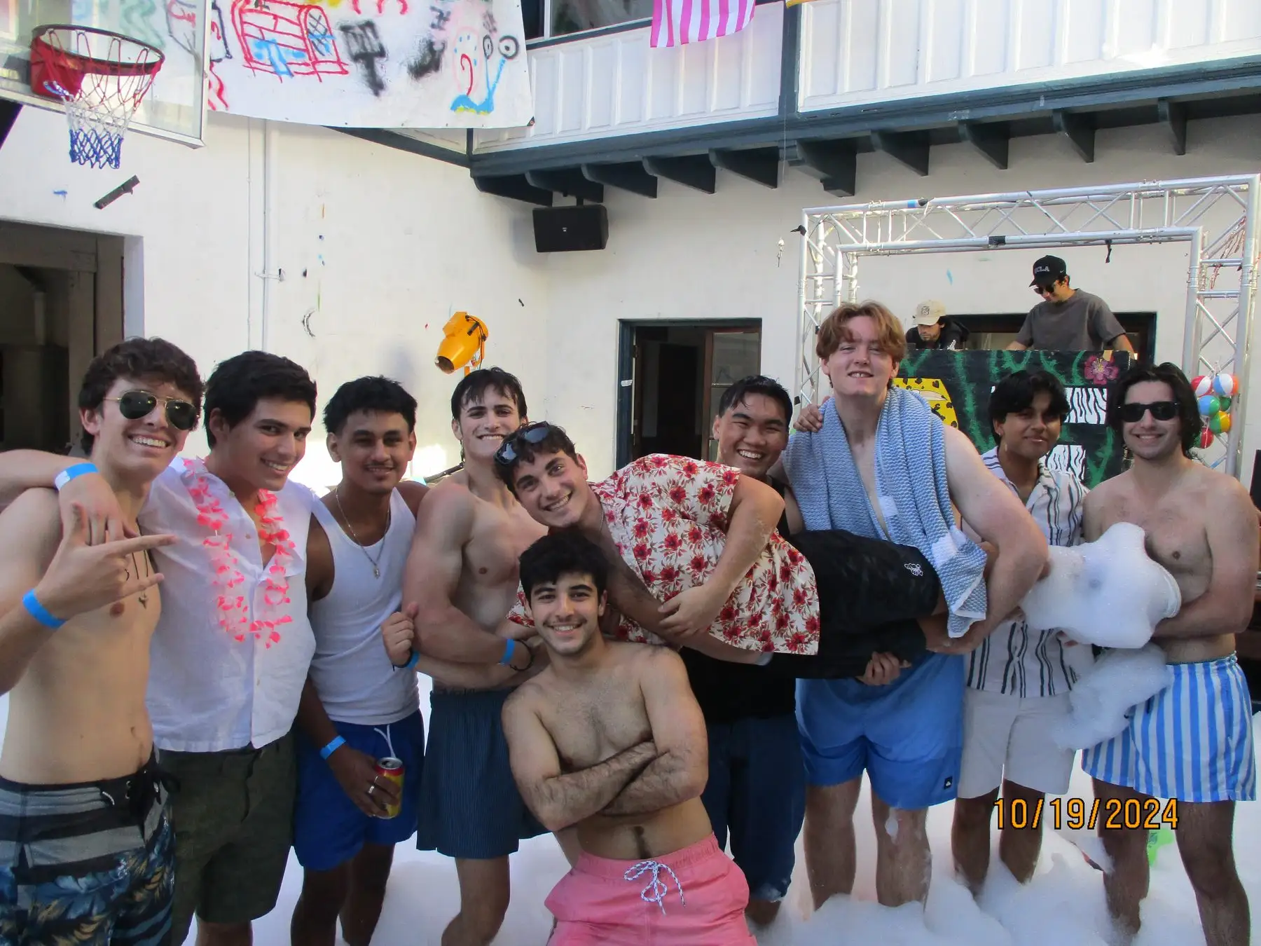 Brothers lifting a friend at the foam party