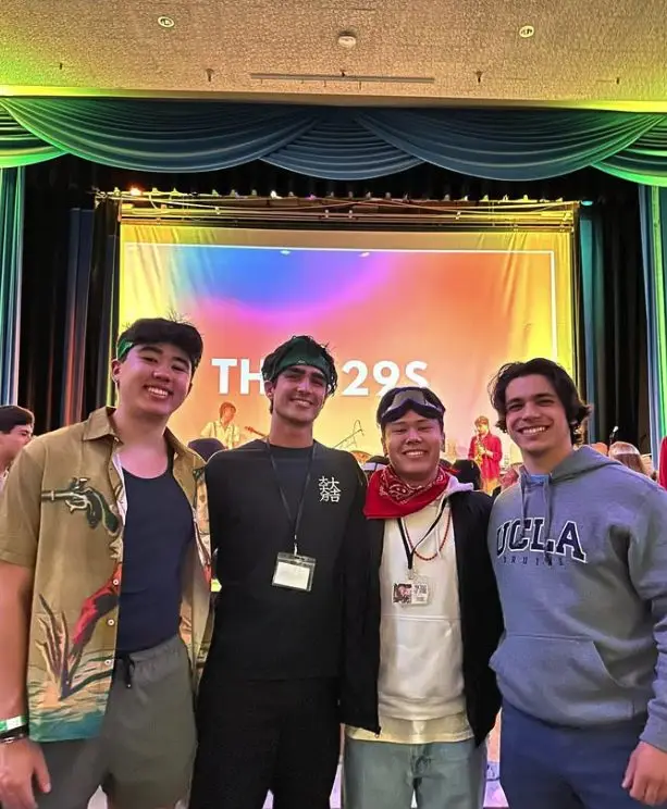 Four brothers smiling in front of the Dance Marathon stage