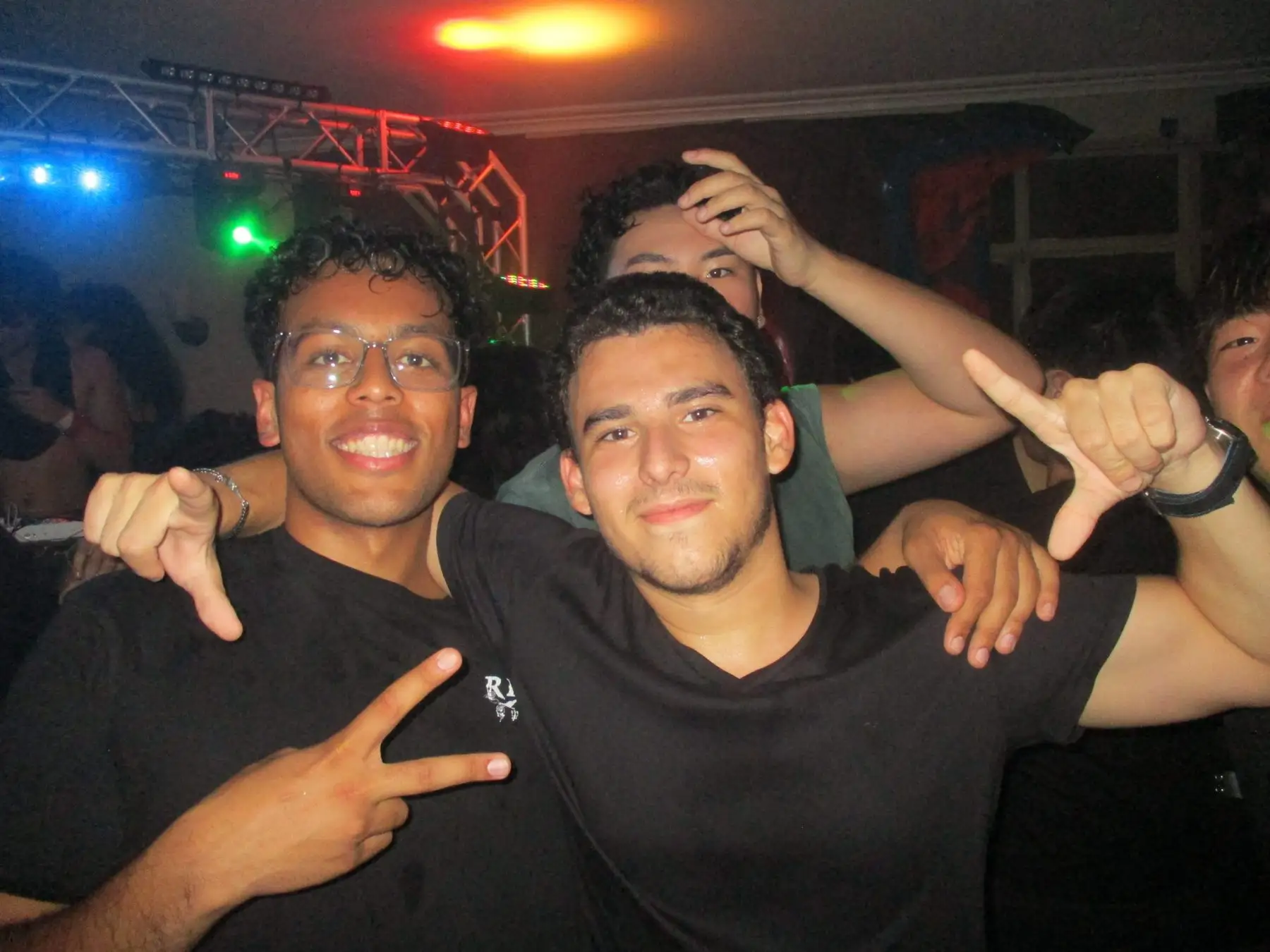 Two brothers throwing hand signs under the party lights