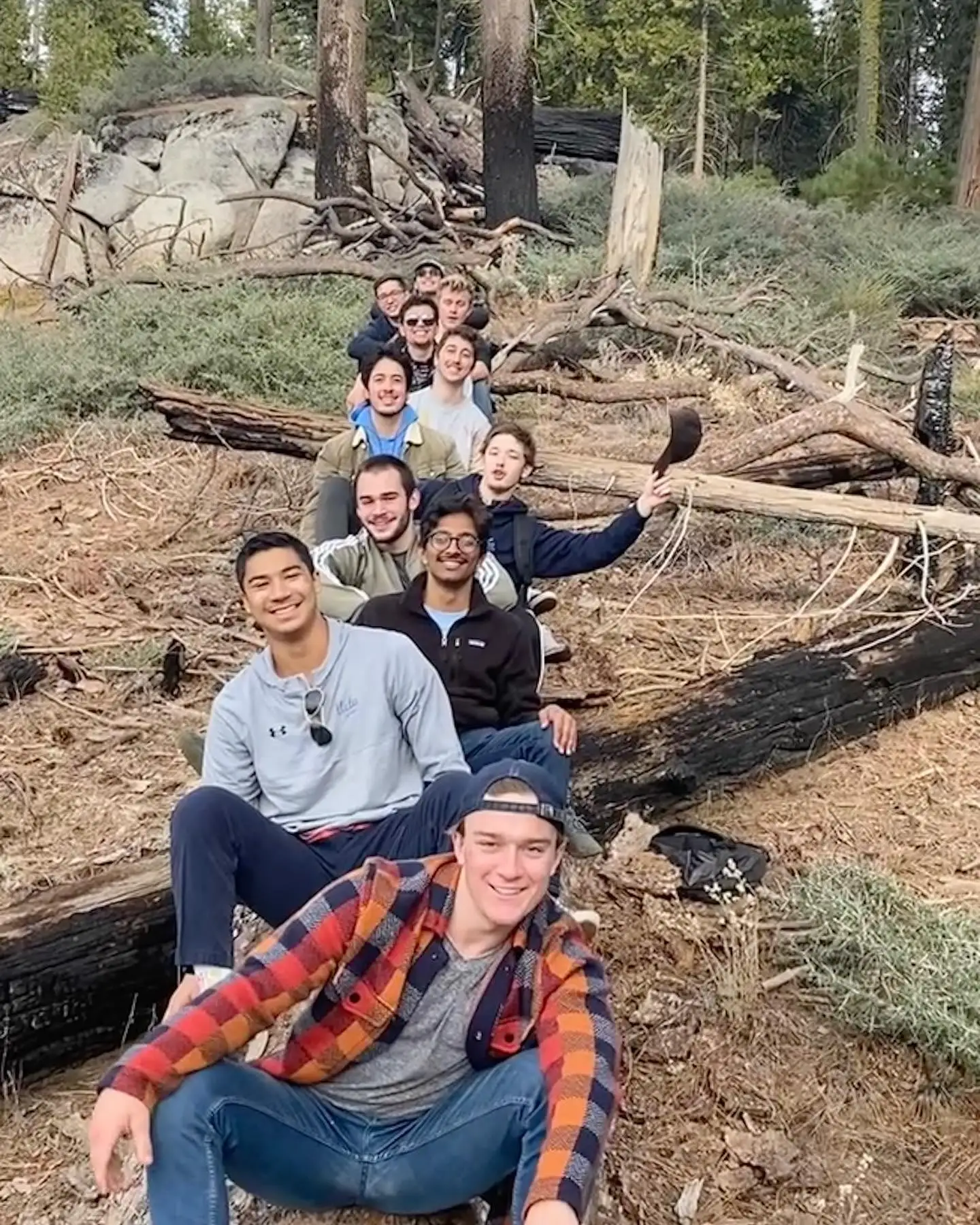 retreat group on logs in forest