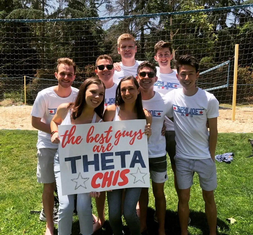 volleyball group with theta chi sign