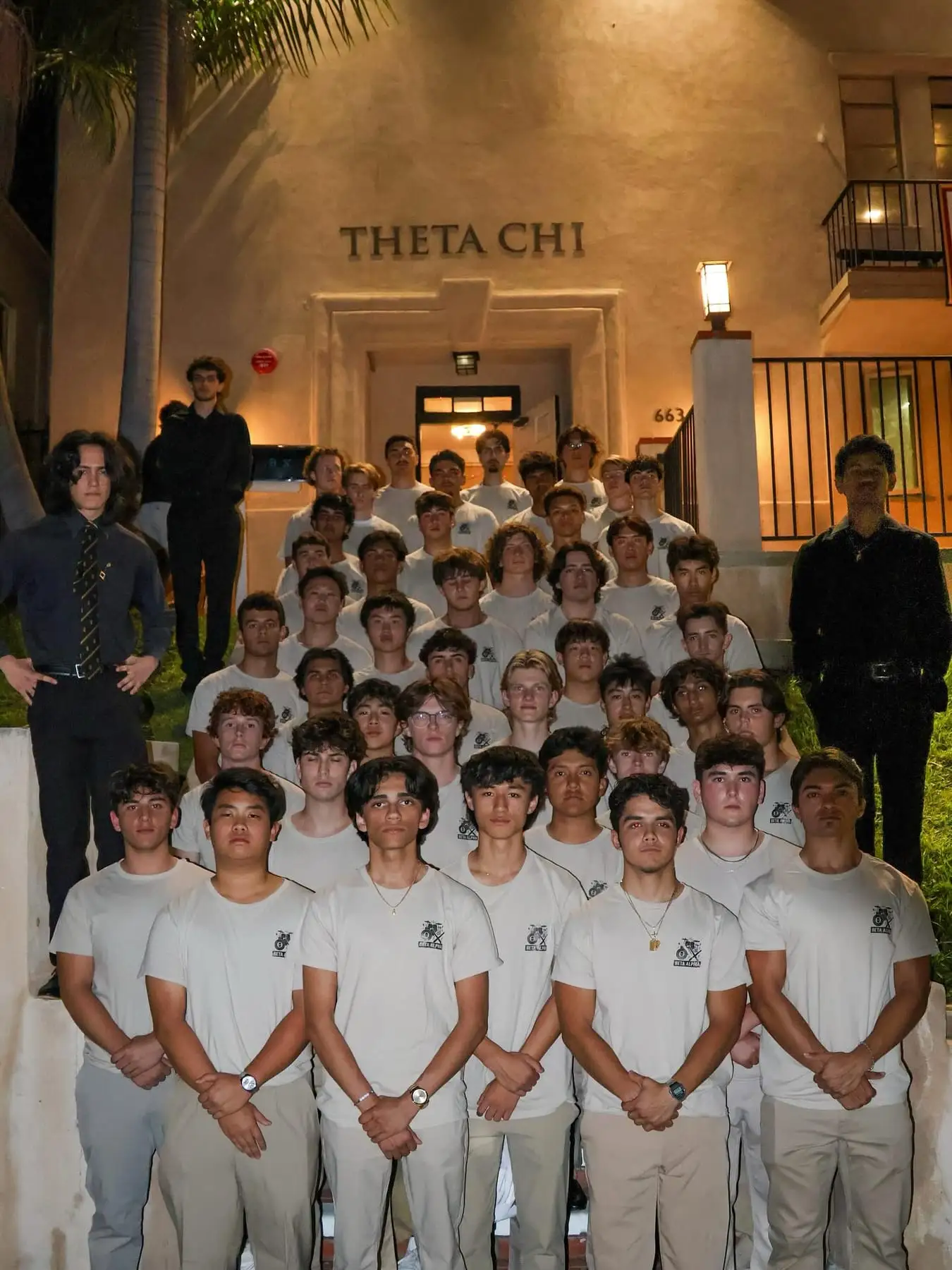 full chapter class photo in front of Theta Chi house