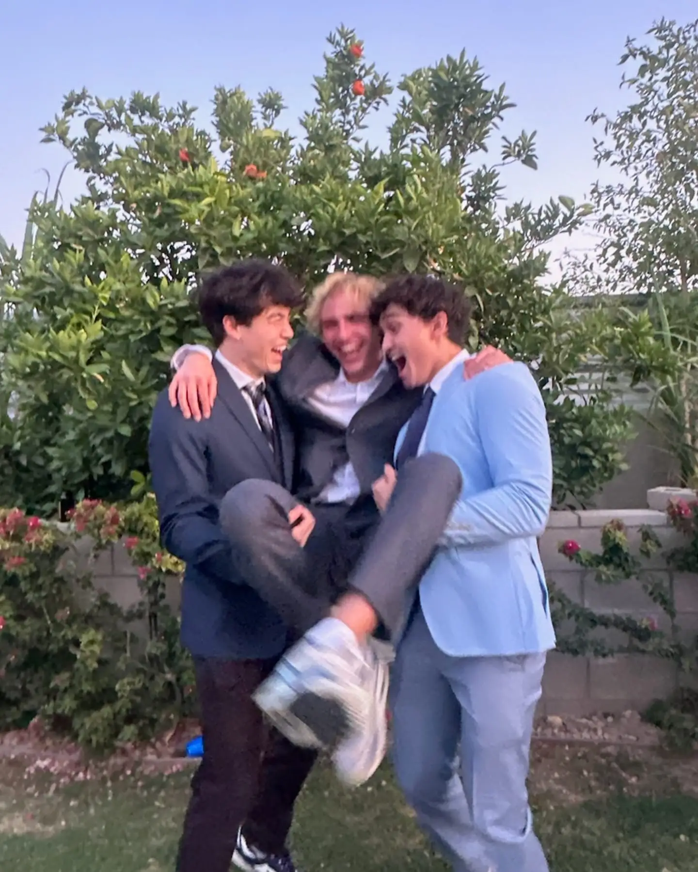 suits carrying laughing friend